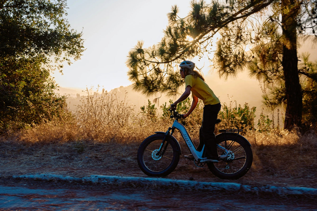 Rider on an Aventon Aventure 3 on a forest trail at sunset