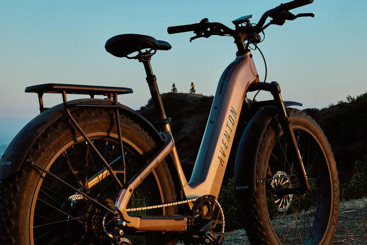 Aventon fat-tire e-bike parked on a coastal bluff at dusk